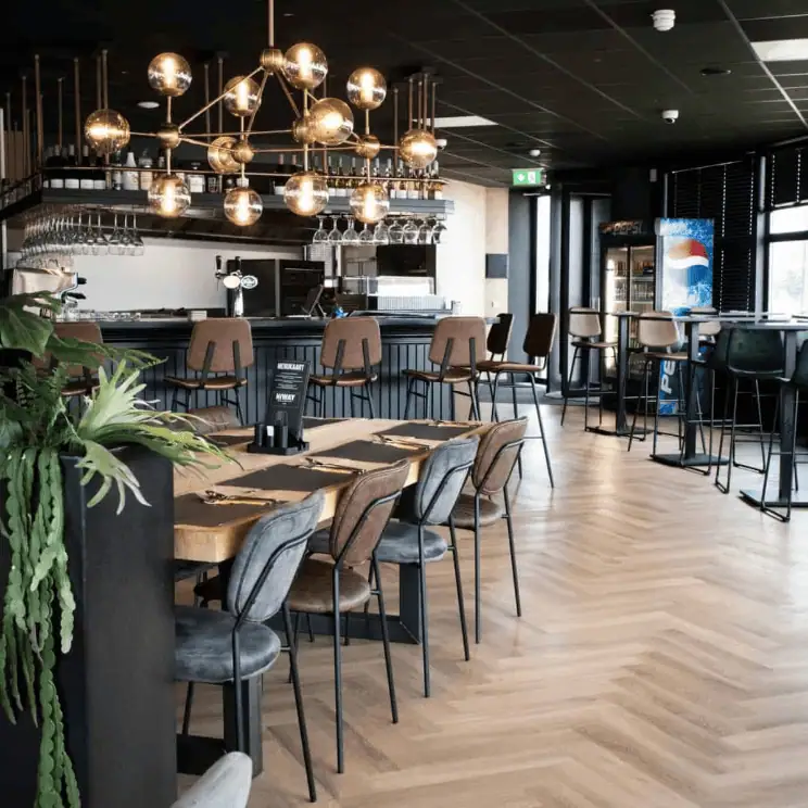 Super-Seat | Das moderne Restaurant-Interieur | Houten vloer, zentraler Tisch, gewatteerde Stoelen, hohe Barkrukken, goldene Kroonluchter. | Horecameubilair